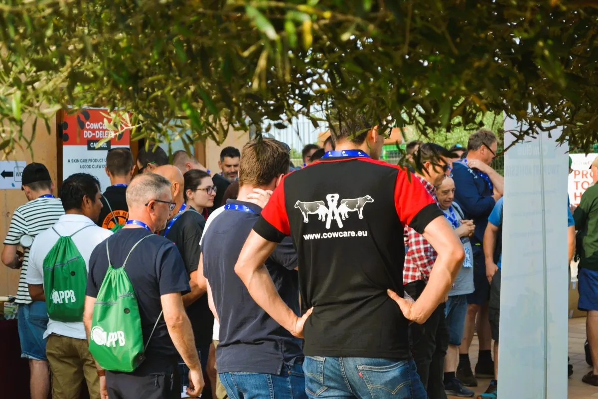 cowcare hoof trimmers meeting in a crowd
